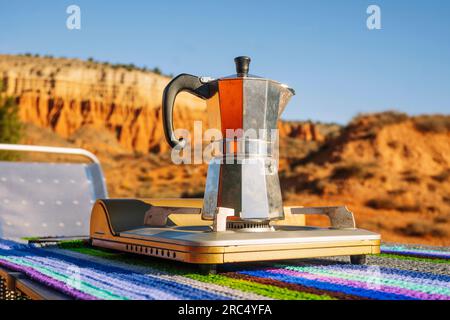 Camping café métallique moka pot sur cuisinière à gaz portable sur table colorée dans la nature du canyon Rojo Teruel Espagne Banque D'Images
