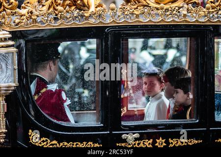 Rainy London voit la princesse Charlotte et les princes George et Louis rouler avec leurs parents dans l'autocar de l'État du jubilé de diamants le jour du couronnement. Banque D'Images