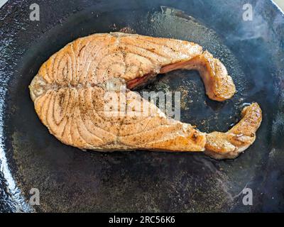 Steak de saumon frit dans une poêle en fonte, vue de dessus Banque D'Images