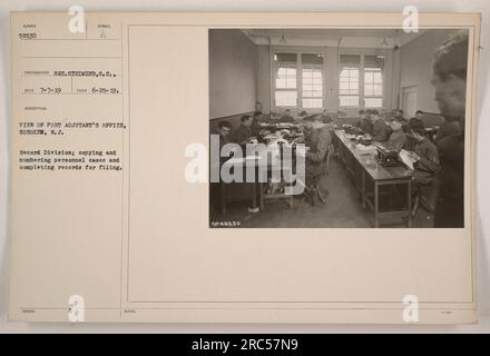 Photographie montrant le bureau de Port Adjutant à Hoboken, New Jersey pendant la première Guerre mondiale. Sur l'image, le personnel de la Division des dossiers peut être vu en train de copier et numéroter des dossiers personnels et de remplir des dossiers pour classement. La photographie a été prise par le photographe SOT. Strimzer le 25 juin 1919 et reçu le 7 juillet 1919. Le symbole de description est A. il est répertorié comme élément 88530 dans les notes. Banque D'Images