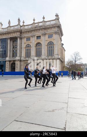 Turin, Italie - 27 mars 2022 : groupe de jeunes exécutant une chorégraphie dansante pour un tournage vidéo à la Piazza Castello, Turin. Banque D'Images