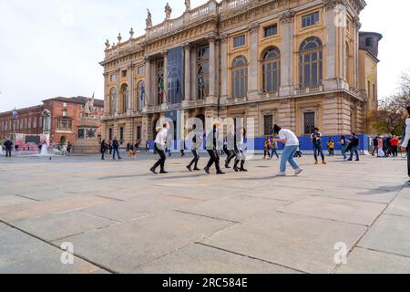 Turin, Italie - 27 mars 2022 : groupe de jeunes exécutant une chorégraphie dansante pour un tournage vidéo à la Piazza Castello, Turin. Banque D'Images