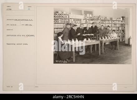 Soldat inspectant des boîtes de pois dans le cadre du processus d'inspection des aliments pour les États-Unis Armée pendant la première Guerre mondiale. La photographie a été prise par le sergent McGarrigle le 3 mai 1919. Source de l'image : Sumber A. Notes officielles : n° 47725 Banque D'Images