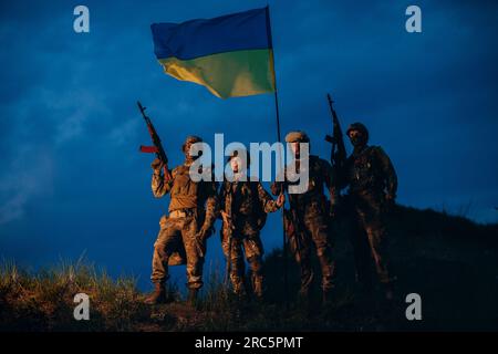 Portrait de guerriers ukrainiens avec un drapeau national dans la soirée Banque D'Images