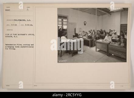 La vue du bureau de Port Adjutant à Hoboken (N.J.) montre que le personnel trie et organise les dossiers d'embarquement par ordre alphabétique pour le classement. Cette photographie a été prise le 25 juin 1919 par le sergent Stemizer, S.C. L'image est classée sous le numéro 58527 dans la collection de photographies des activités militaires américaines pendant la première Guerre mondiale. Banque D'Images