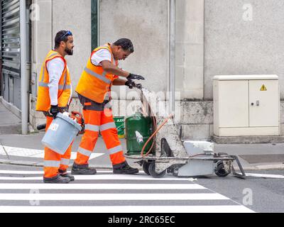 Ouvriers du conseil peignant des marquages de passage piétonnier en centre-ville - Tours, Indre-et-Loire (37), France. Banque D'Images