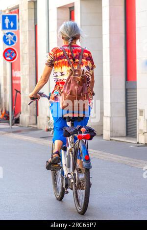 Femme mature à vélo à travers le centre-ville - Tours, Indre-et-Loire (37), France. Banque D'Images