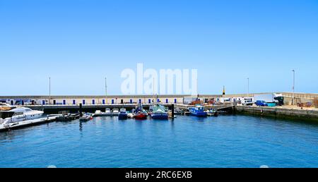 Lanzarote Îles Canaries Puerto Del Carmen l'entrée du port depuis l'océan avec des écoles de plongée et des bateaux contre un ciel bleu profond Banque D'Images