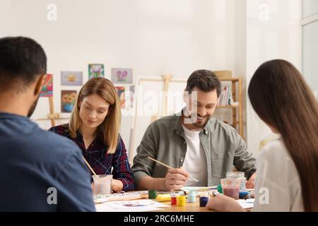 Groupe d'étudiants assistant à un cours de peinture en studio. Passe-temps créatif Banque D'Images