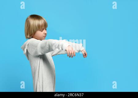 Un garçon en pyjama marche sur fond bleu clair Banque D'Images