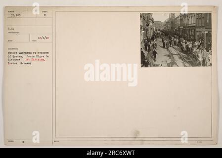 Les troupes de la 1e division marchent dans les rues de Treves, en Allemagne, le 1 décembre 1918. La Porta Nigra peut être vue au loin. Cette photographie a été prise par S.C. Photographe Reco 1830ED avec le numéro d'identification 33,186. Une note avec '33186' est également incluse. Banque D'Images