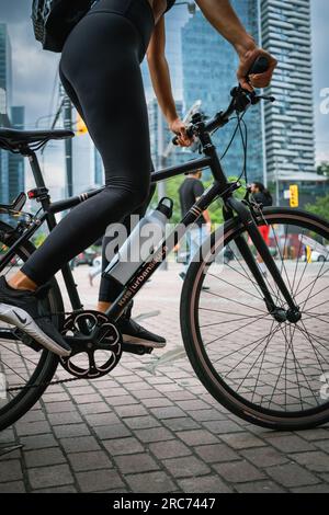 Gros plan des jambes de jeune femme sur le vélo à l'extérieur dans la rue de la ville. Recadrez la photo d'une athlète en forme active faisant du vélo dans le centre-ville de Toronto Canada-Ju Banque D'Images