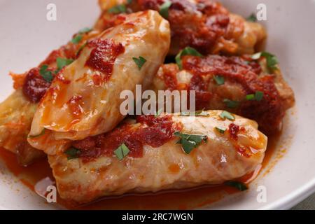 Délicieux petits pains de chou farcis cuits avec de la sauce tomate maison dans un bol, gros plan Banque D'Images