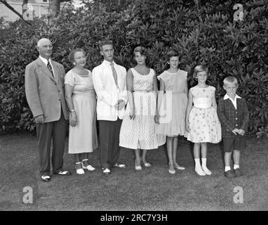 Californie : c. 1960 Un mari et une femme avec cinq enfants se tiennent dehors pour un portrait de famille. Banque D'Images