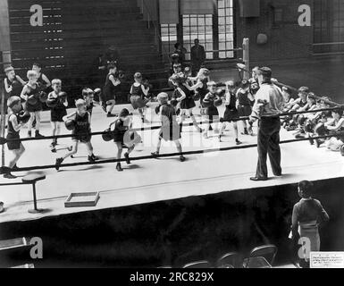 Annapolis, Maryland : mai 1941 les 22e championnats annuels de boxe junior de la Marine sont ouverts aux fils des officiers de l'Académie navale. Ici, la mêlée générale a commencé parmi les 21 jeunes qui se balancent librement dans le ring sous l'œil vigilant de l'instructeur 'Spike' Webb. Banque D'Images