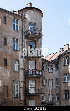 Ancienne façade patinée avec balcons sur un coin arrondi dans le centre de Riga, Lettonie Banque D'Images