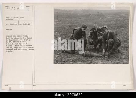 Des soldats américains inspectent une seule munition, un obus explosif français de 155 mm de haut, à Romagne sur Montfaucon, Meuse, France. De gauche à droite : le 2e lieutenant Frank B. Ingersoll du département des ordonnances, le 2e lieutenant Edward T. Tedd des États-Unis Army signal corps, et Sgt. C.M. Condon. Photographie prise le 25 janvier 1919 par S.C. Fineberg.' Banque D'Images