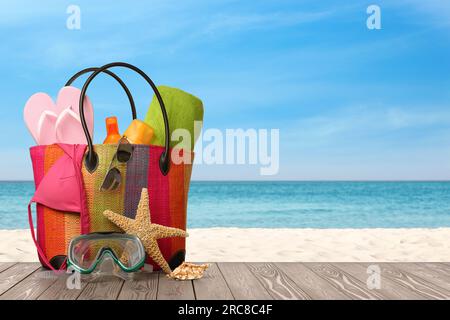 Sac avec masque de plongée sous-marine et accessoires sur la plage ensoleillée de l'océan, espace pour le texte. Vacances d'été Banque D'Images