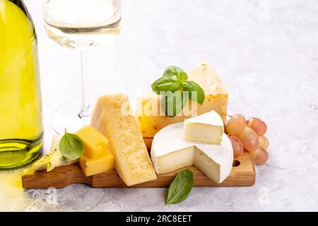 Divers fromages à bord et vin blanc Banque D'Images