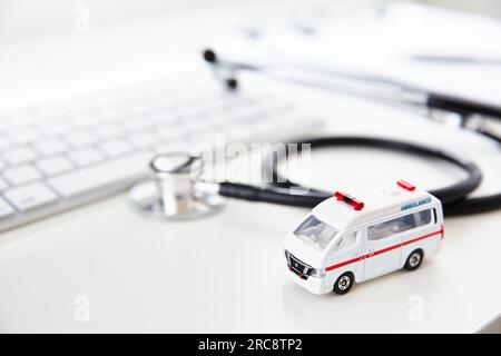 Un stéthoscope devant un ordinateur et une ambulance miniature Banque D'Images