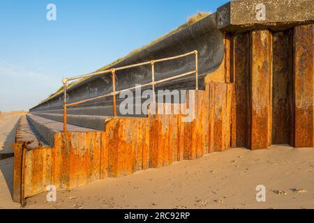 Défenses maritimes en acier et béton sur la côte de la mer du Nord à Happisburgh dans le Norfolk, Angleterre. Banque D'Images