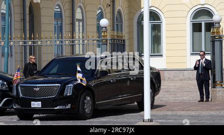 Helsinki, Finlande. 13 juillet 2023. Un garde de sécurité instruit le conducteur des États-Unis Limousine du président, surnommée « la Bête », devant le palais présidentiel finlandais à Helsinki. ÉTATS-UNIS Le président Joe Biden rencontrait le président finlandais Niinistö pour une réunion bilatérale, après quoi un sommet avec les chefs de gouvernement des autres pays nordiques était prévu au palais. Crédit : Steffen Trumpf/dpa/Alamy Live News Banque D'Images