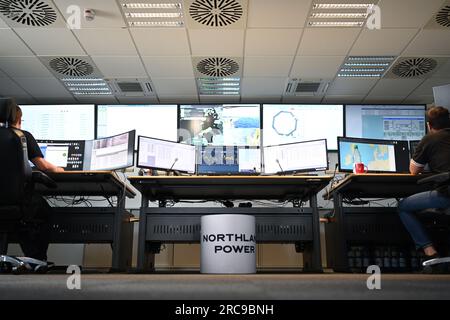 Norddeich, Allemagne. 13 juillet 2023. Deux employés de la société « North Power » surveillent les parcs éoliens offshore en mer du Nord dans la salle de contrôle du site de Norddeich. Crédit : Lars Penning/dpa/Alamy Live News Banque D'Images