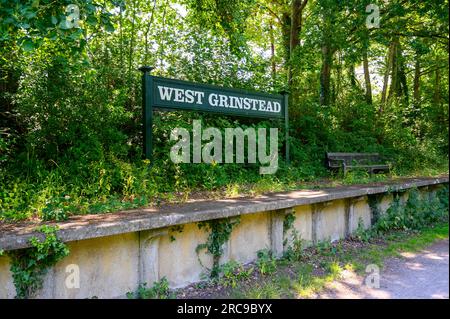 L'ancienne et défunte plate-forme de la gare de West Grinstead et panneau sur le chemin Downs Link, une ancienne ligne de chemin de fer dans le West Sussex, en Angleterre. Banque D'Images