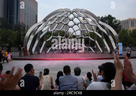 (230713) -- PÉKIN, 13 juillet 2023 (Xinhua) -- les gens regardent une représentation en soirée sur la rivière Liangma à Pékin, capitale de la Chine, le 23 juin 2023. La Seine, deuxième plus grande rivière de France, serpente au cœur de Paris. S'écoulant d'ouest en est, il divise la ville en deux : la « rive gauche » et la « rive droite ». La rive gauche est définie par une ambiance artistique, ornée de cafés, théâtres et librairies, créant un havre pour le cercle littéraire et un paradis culturel. D’autre part, la rive droite abrite des monuments prestigieux tels que le Louvre, l’ancien palac royal Banque D'Images