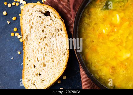Soupe appétissante aux pois chauds et oignon servis avec des tranches de pain Banque D'Images