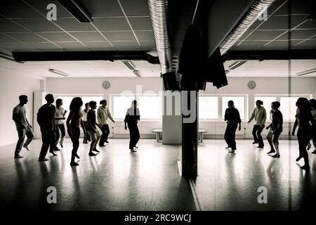 Des élèves adolescents répètent avec une enseignante dans un studio de danse au lycée Banque D'Images