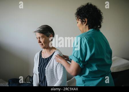 Médecin féminin examinant le patient âgé en clinique Banque D'Images