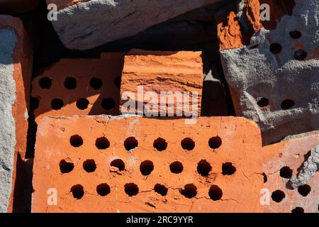 Un tas de vieilles briques rouges avec les restes de mortier séché. Matériau de construction brique rouge avec des trous. Briques en argile solide utilisées pour la construction. Concept de Banque D'Images