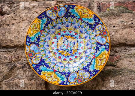 Produit artisanal typique, assiettes peintes à la main accrochées au mur d'une boutique de souvenirs à Sienne, Toscane, Italie. Banque D'Images
