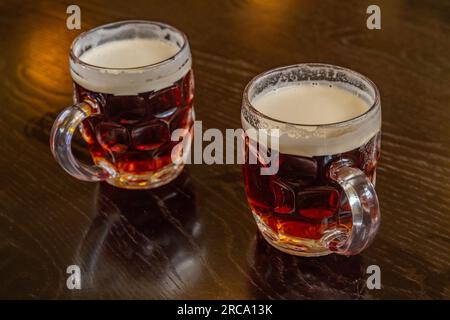 2 demi pintes de bière douce sur une table en bois poli. Banque D'Images