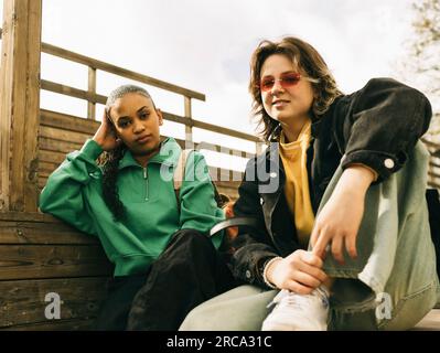Portrait de jeunes amies assises sur des marches Banque D'Images