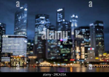 Image floue bokeh de gratte-ciel autour de Marina Bay à Singapour la nuit Banque D'Images