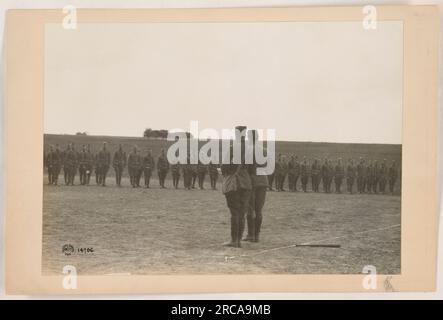 Soldats de l'armée américaine participant à la première Guerre mondiale Les soldats sont vus marchant en formation, avec leurs fusils à la main, accompagnés d'un porte-drapeau. Cette image illustre le dévouement et la discipline des forces américaines pendant la guerre. Banque D'Images