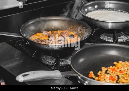 Deux casseroles avec risotto cuisant sur une cuisinière Banque D'Images