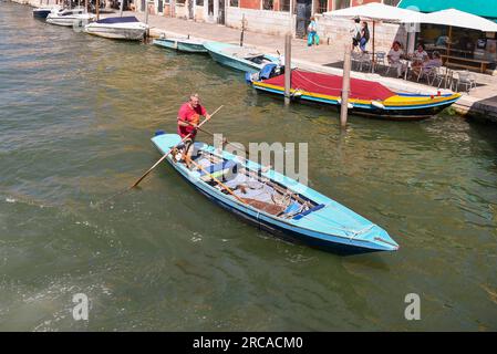 Vue à grand angle d'un homme âgé debout aviron dans le style vénitien rangée sur le Rio della Misericordia en été, Venise, Vénétie, Italie Banque D'Images