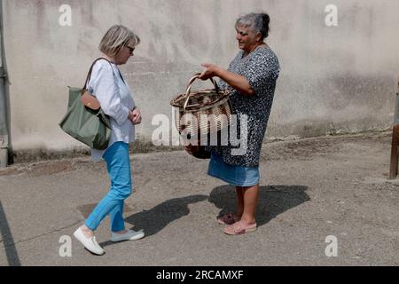 Roma Gypsy Woman France. Femmes roms françaises vendant des paniers en osier faits à la main aux touristes dans la rue à Saint Michel en Greve, Côtes-d'Armor, Bretagne, France . 10 juillet 2023. HOMER SYKES des années 2020. Banque D'Images