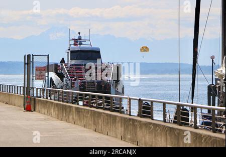 Salish Sea Tours bateau Orca One arrivant à Pier 57 avec un parachute ascensionnel avec deux personnes en arrière-plan Elliott Bay Seattle Washington State USA Banque D'Images