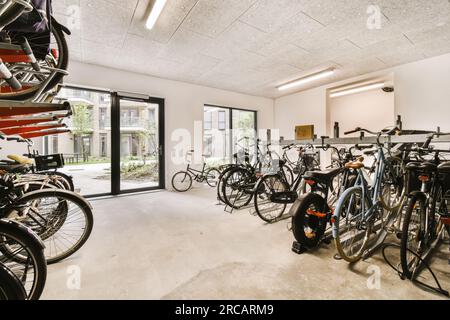 quelques vélos dans une pièce avec beaucoup de lumière provenant des fenêtres et des portes de chaque côté du bâtiment Banque D'Images