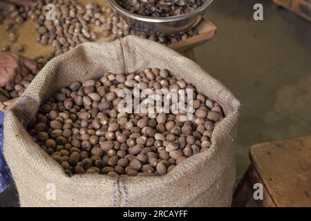 Haricots de muscade en sac de toile. Grains entiers emballés dans des sacs en vrac. Haricots crus. Haricots en vrac Banque D'Images