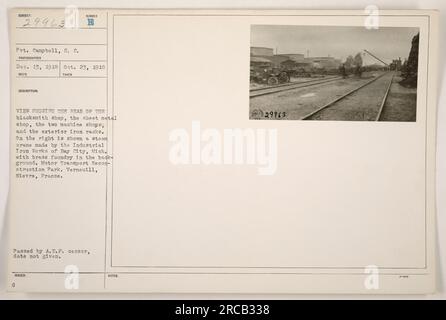 Cette photographie montre la vue arrière de divers bâtiments du Motor transport reconstruction Park à Verneuill, Nièvre, France pendant la première Guerre mondiale. L'atelier de forgeron, l'atelier de tôlerie, et deux ateliers d'usinage sont visibles, ainsi que des supports de fer extérieurs. En arrière-plan, une grue à vapeur fabriquée par Industrial Iron Works de Bay City, Michigan, est représentée, avec une fonderie de laiton en arrière-plan lointain. La date à laquelle la photographie a été prise et les détails sur le soldat Campbell sont inconnus. Légende : « vue arrière des bâtiments du Motor transport reconstruction Park à Verneuill, Nièvre, France pendant la guerre mondiale Banque D'Images