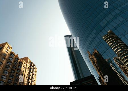 Bakou, Azerbaïdjan - 26 juin 2023 : prise de vue matinale capturant les bâtiments historiques et modernes de Bakou reflétés dans les fenêtres d'un gratte-ciel Banque D'Images