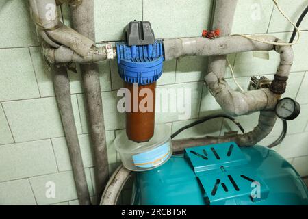 Ancien filtre domestique et tuyaux dans le système d'alimentation en eau de la maison. Filtre rouillé sale pour la purification de l'eau. Remplacement de la cartouche du filtre à eau multi-étagé Banque D'Images