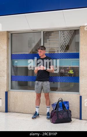 13 juillet 2023. Inverness City, Highlands and Islands, Écosse. C'est un homme en kit sportif athlétique et en utilisant son téléphone portable en attendant un train Banque D'Images