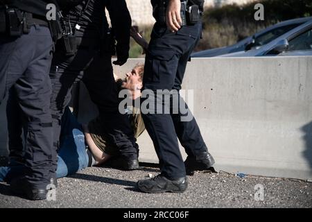 Jérusalem, Israël. 11 juillet 2023. Des policiers arrêtent un manifestant lors d'une manifestation de réservistes israéliens contre la réforme judiciaire au cours de laquelle des manifestants ont bloqué l'autoroute tel Aviv-Jérusalem à la jonction Ein Hemed. (Image de crédit : © Matan Golan/SOPA Images via ZUMA Press Wire) USAGE ÉDITORIAL SEULEMENT! Non destiné à UN USAGE commercial ! Banque D'Images