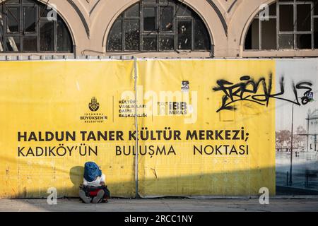 Istanbul, Turquie. 13 juillet 2023. Un homme se couvre du soleil en étant assis par terre près du quai de Kadikoy pendant le temps chaud à Istanbul. (Photo Onur Dogman/SOPA Images/Sipa USA) crédit : SIPA USA/Alamy Live News Banque D'Images